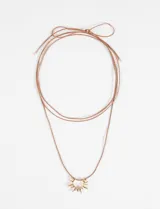 Collar largo de cordón fino color marrón con dije metálico plateado en forma de sol.