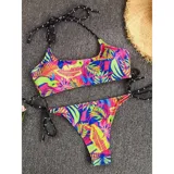 Bikini de dos piezas con estampado tropical vibrante en tonos neón. El top es de estilo deportivo con breteles finos y la bombacha es tipo tanga con tiras laterales ajustables.