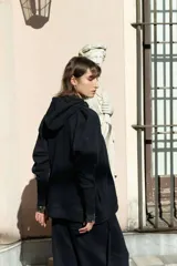 Campera deportiva oversize color bordó con capucha, cierre metálico frontal y mangas raglán de volumen pronunciado. Cuenta con puños largos de rib elástico y cordones regulables a tono con terminaciones metálicas.