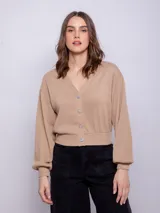 Cárdigan corto color beige, de manga larga y escote en V. Tiene cuatro botones brillantes.