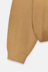 Chaqueta de punto color tostado con cuello en pico, manga larga con puños y cierre frontal con botones.