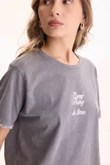 Remera cropped de algodón color gris con efecto lavado y mangas cortas. Cuenta con bordado en el pecho con la frase 'Every thing in time' y costuras decorativas visibles en contraste en los dobladillos.