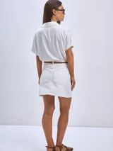 Minifalda blanca de denim con bolsillos delanteros y traseros.