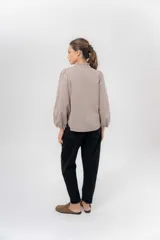 Pantalón de gabardina azul marino, de corte barrel y tiro bajo, con detalles en pana marrón en la pretina y en el ruedo interior vuelto.