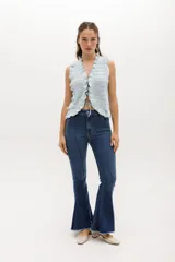 Pantalón jean acampanado de tiro alto, color azul denim, con alforza central.