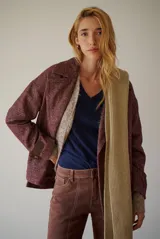 Chaquetón de lana color bordó con diseño de espiga y motas blancas. Tiene solapa, doble abotonadura frontal, mangas largas con detalle de correa y hebilla en los puños.