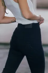 Pantalón jean negro de tiro medio alto y corte oxford con botamanga ancha al corte.