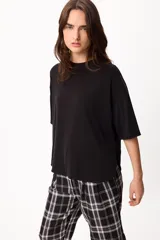 Remera básica de algodón color negro, con cuello redondo y detalle de bordado en el hombro.