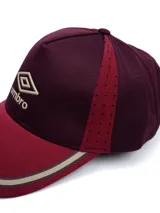 Gorro tipo visera Umbro modelo Trener, en colores bordo y rojo, con logo de la marca bordado en el frente y detalles en tono tostado en la visera.