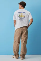 Remera blanca de algodón, de corte holgado y mangas cortas, con pequeño estampado azul en el pecho.
