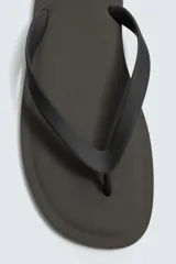 Sandalia tipo chinela de hombre, con suela plana color verde oscuro y tiras negras en el empeine.