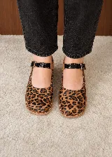 Zapatos de taco ancho con diseño destalonado y pulsera con hebilla en el empeine. Presentan una combinación de cuero con estampado animal print de leopardo, tono camel y detalles en negro charol.