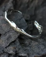 Brazalete rígido abierto de plata 925 con diseño orgánico irregular.