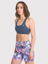 Top deportivo azul con espalda racerback y logo estampado en el frente. Cuenta con almohadillas removibles y sujetador integrado. Ideal para actividades de medio impacto.