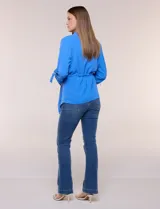 Chaqueta liviana azul de silueta fluida y diseño abierto, con solapa caída, mangas tres cuartos con presilla y argolla metálica, y ruedo irregular.