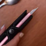 Billetera tipo tarjetero de cuero negro con caja de aluminio interna y sistema de deslizamiento para tarjetas. Cuenta con cierre mediante broche a presión.