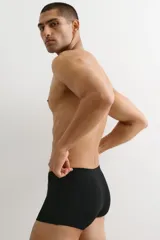 Pack de tres calzoncillos tipo bóxer trunk negros, de punto elástico de algodón, con costuras planas, elástico revestido en la cintura y frente forrado.