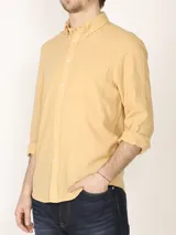 Camisa de manga larga confeccionada en una mezcla de algodón y lino, con cuello abotonado, bolsillo frontal en el pecho y cierre de botones.