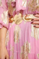 Cinto elastizado color beige con tres apliques circulares dorados.