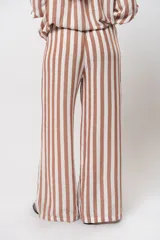 Pantalón largo de lino a rayas verticales color marrón y blanco, con cintura elástica y bolsillos laterales.