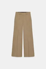 Pantalón de tiro medio confeccionado en tejido con lana, de corte recto y pernera ancha. Presenta detalle de nervio delantero, trabillas en la cintura, bolsillos laterales y cierre frontal con cremallera, botón y ganchos metálicos.