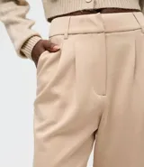 Pantalón wide leg de modal color beige, con tiro alto, pliegues delanteros y bolsillos laterales tipo cuchillo. Cuenta con trabillas en la cintura.