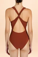 Malla enteriza color terracota con escote profundo en V, tirantes cruzados en la espalda y detalle de frunces cruzados en la cintura.