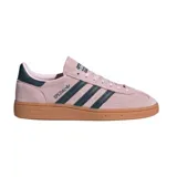 Championes adidas modelo Handball Spezial, confeccionados en gamuza color rosado con las icónicas tres tiras y detalle en el talón en color azul oscuro. Presentan una suela de goma color caramelo que aporta un estilo retro y distintivo.