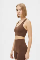 Top deportivo negro de tejido acanalado, con escote redondo y diseño ajustado al cuerpo.
