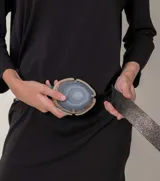 Cinto de cuero azul con hebilla circular de piedra ágata con borde dorado.