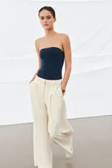 Body strapless de corte ajustado, confeccionado en tejido de poliamida, con cierre inferior mediante botones a presión.