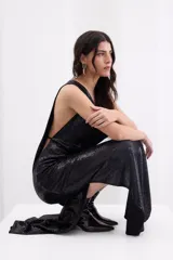 Vestido largo negro de crepe elástico con brillo, sin mangas, con escote drapeado y corte recto y fluido.