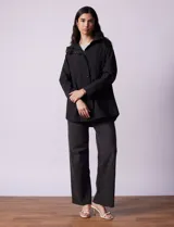 Campera impermeable color gris claro, marca Gallery. Tiene abertura central con cierre oculto y botones a presión, bolsillos delanteros y capucha plegable en el cuello.