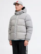 Campera puffer de corte regular, color gris, con capucha desmontable, cierre frontal con solapa, puños elásticos y diseño acolchado horizontal.