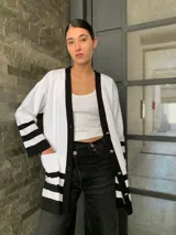 Saco blanco con ribetes negros, de tejido de punto y corte oversize.