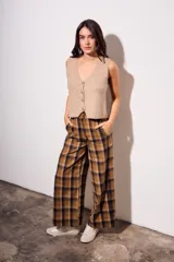 Chaleco de punto sin mangas, color camel jaspeado, con escote en V y cierre frontal de tres botones marrones.