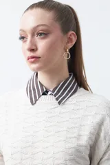 Sweater de punto tramado color azul marino, con cuello redondo, mangas abullonadas y puños elastizados.