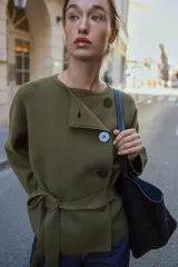 Chaqueta de punto color verde militar, con cuello redondo, manga larga y cierre frontal cruzado con botones. Incluye un cinturón del mismo tejido para ajustar en la cintura.