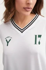 Camiseta blanca oversize de manga larga con cuello en V y número 17 estampado en el pecho.