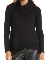 Buzo de punto color beige con cuello volcado amplio, mangas largas acanaladas y torso liso. Presenta una costura central vertical, ruedo con tajos laterales y largo asimétrico, siendo más largo en la parte posterior.