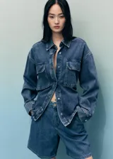 Short de denim azul de tiro medio, con bolsillos laterales, bolsillos traseros, trabillas para cinturón y detalle de pinzas delanteras.