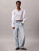 Remera de corte slim confeccionada en punto de algodón elástico con textura de canalé fino. Presenta cuello en V, manga corta y una insignia con el logo de Calvin Klein en el pecho.