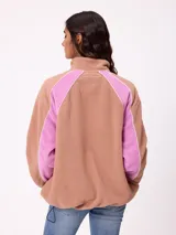 Campera de polar marca Rusty, color azul con paneles laterales en celeste claro. Presenta cierre frontal completo, cuello alto y logo de la marca bordado en el pecho.