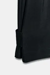 Pantalón fluido de tiro medio confeccionado en mezcla de modal, con cintura elástica ajustable mediante cordones. Presenta pinzas en el delantero, bolsillos laterales ocultos y bajo ajustable con trabilla y botón a presión.