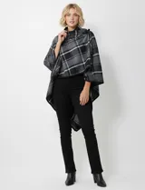 Capa de tejido cuadrille con diseño de cuadros en tonos marrón, beige y naranja. Presenta un cierre frontal con botón tipo trenca y bordes con ribete negro.