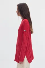 Buzo negro de tejido de ochos, con cuello redondo y diseño oversized de corte largo y amplio con tajos laterales.