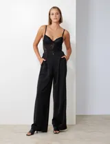 Pantalón palazzo de satén con tiro alto, pretina con pasadores, cierre y botón frontal, y bolsillos laterales. Cuenta con pretina trasera elastizada.