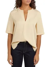 Blusa color crema de Tommy Hilfiger, de corte regular, con cuello en V y mangas cortas.