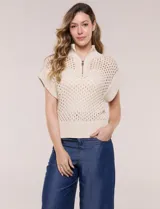 Buzo de punto color marfil, confeccionado en algodón calado con cuello alto acanalado y medio cierre metálico dorado. Presenta mangas cortas estilo japonesa con puños anchos y un zócalo acanalado en el ruedo.