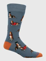 Calcetines de largo medio color gris azulado con estampado de perros Basset Hound con diferentes accesorios. Presenta talón y puntera en color naranja.